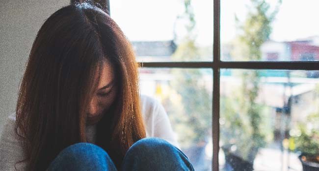 a-sad-young-woman-sitting-alone-in-the-room-650x350