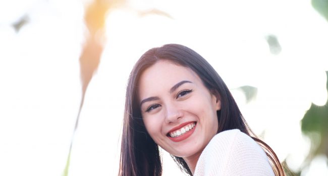 Close up portrait of beautiful friendly woman smiling outside