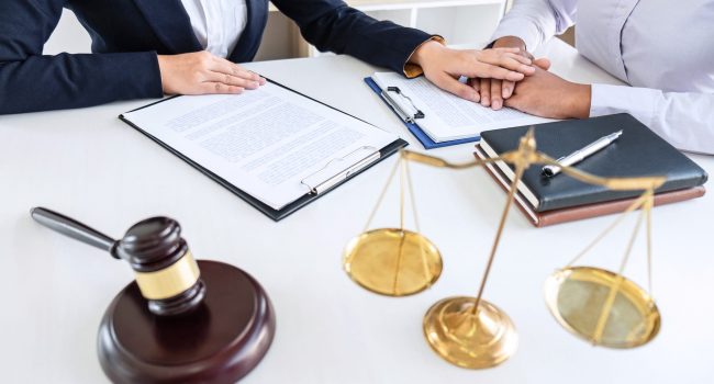 Professional Female lawyer discussing negotiation legal case with client meeting with document contact in courtroom, law and justice concept Professional Female lawyer discussing negotiation legal case with client meeting with document contact in courtroom, law and justice concept.