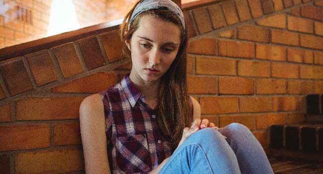 sad-schoolgirl-sitting-alone-on-staircase-650x350